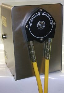 Grey metal case with a black circular case on the front with 2 yellow tubes coming out of either side which is the NDT motor unit